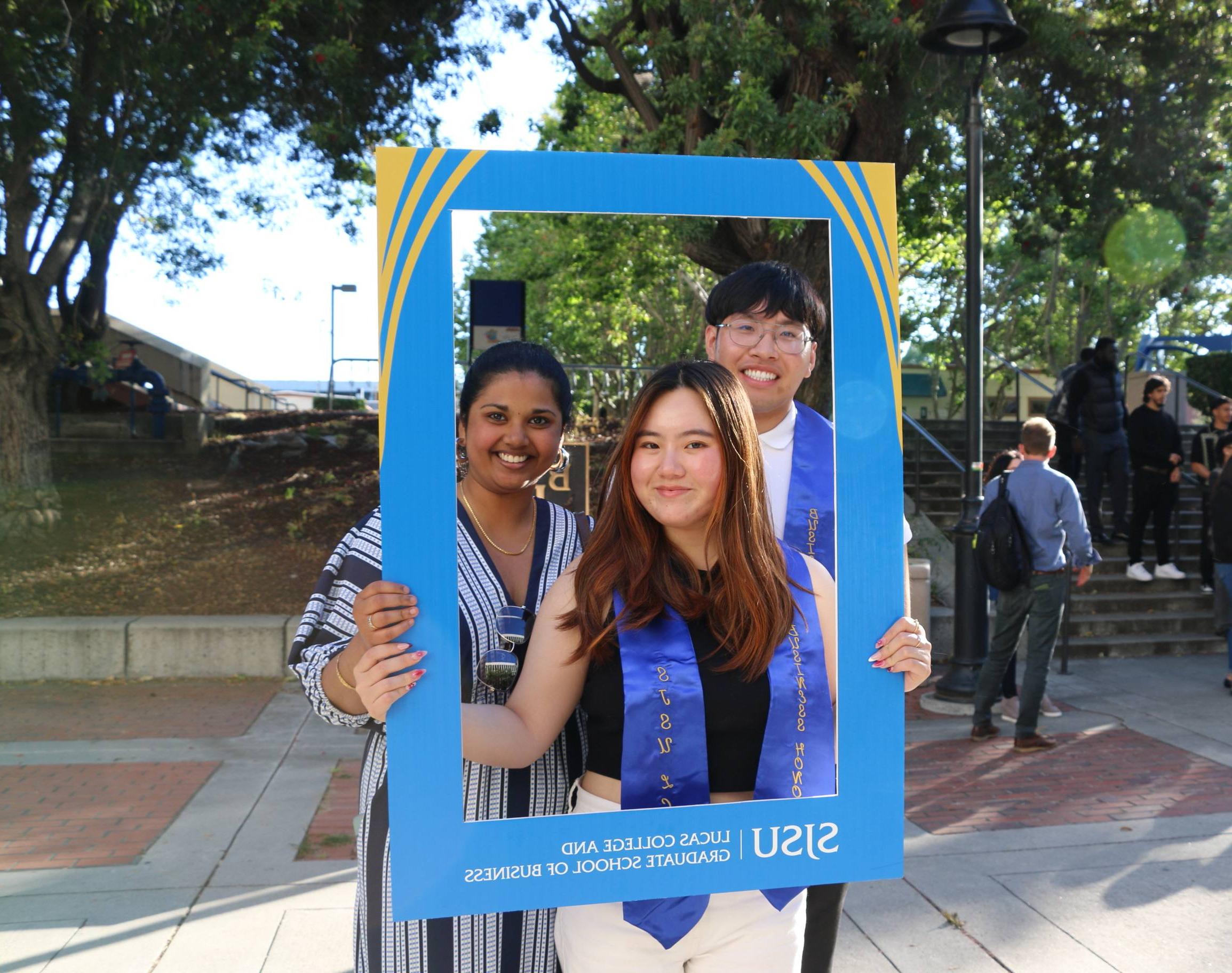 Students pose with a blue and gold LCoB frame